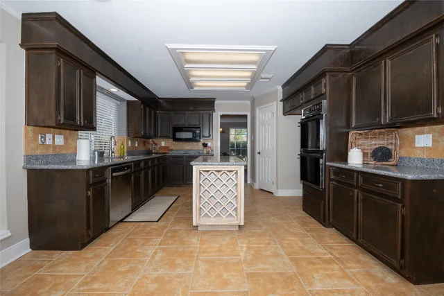 a kitchen with stainless steel appliances granite countertop a refrigerator and a stove top oven