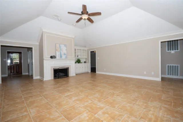 a view of empty room with fireplace and fan