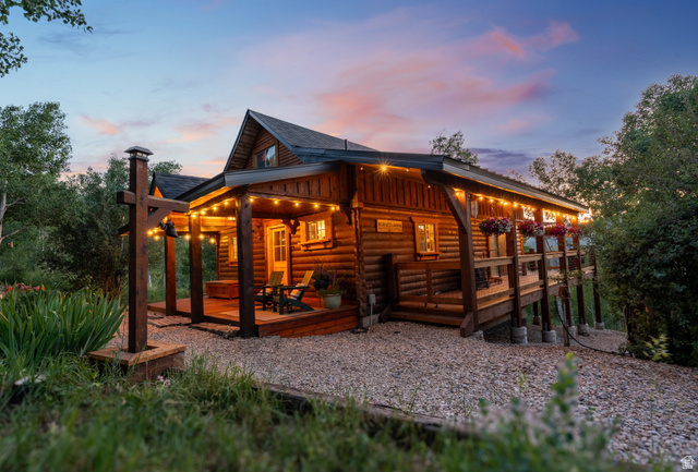 8737 Sage Run Road Kamas, UT 84036 - Photo 1 of 27 Log cabin exterior featuring a covered porch, wrap around deck and surrounding mature trees