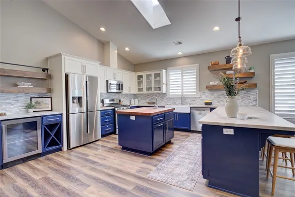 a kitchen with stainless steel appliances granite countertop a sink refrigerator and cabinets