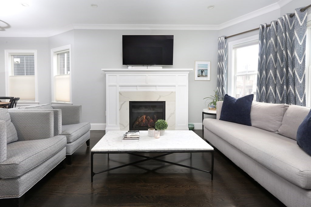 22 Roseclair Street, Unit 1 Boston, MA 02125 - Photo 2 of 14 a living room with furniture a flat screen tv and a fireplace