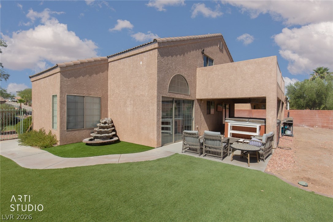 387 Silver Road Mesquite, NV 89027 - Photo 29 of 46 Textured stucco exterior walls pair with a tiled roof above a manicured backyard lawn.