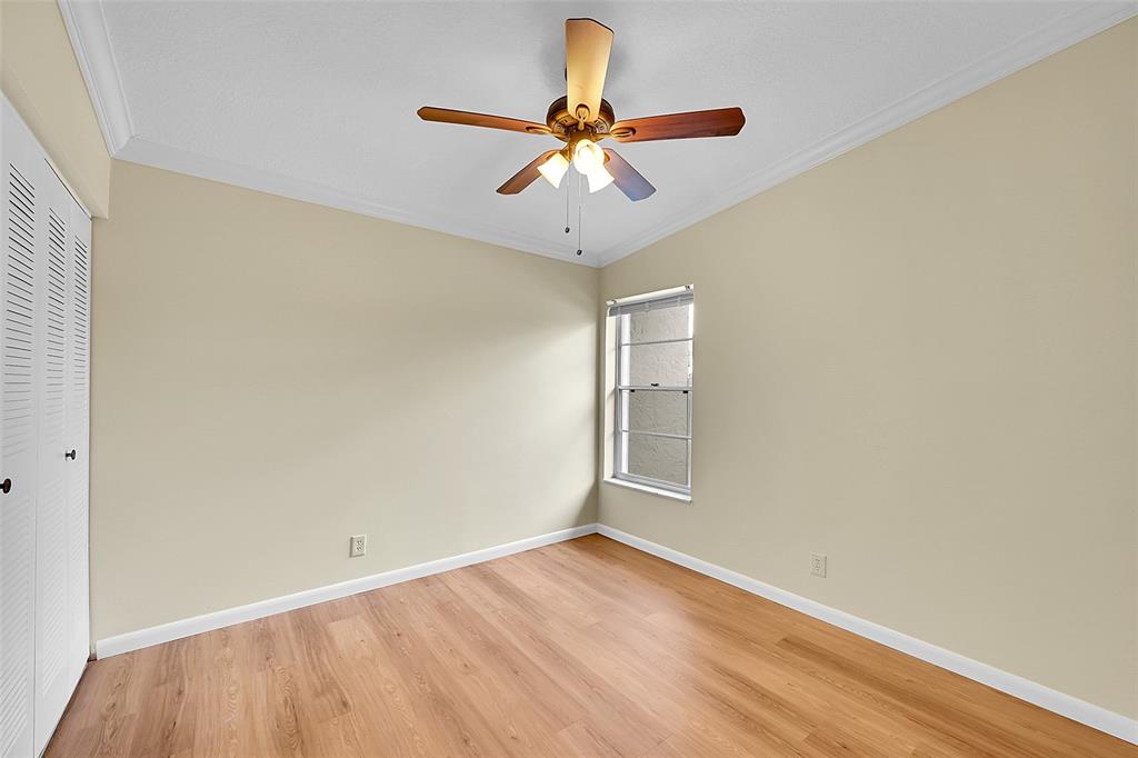 22306 Timberly Drive, Unit 22306 Boca Raton, FL 33428 - Photo 14 of 26 an empty room with wooden floor fan and windows