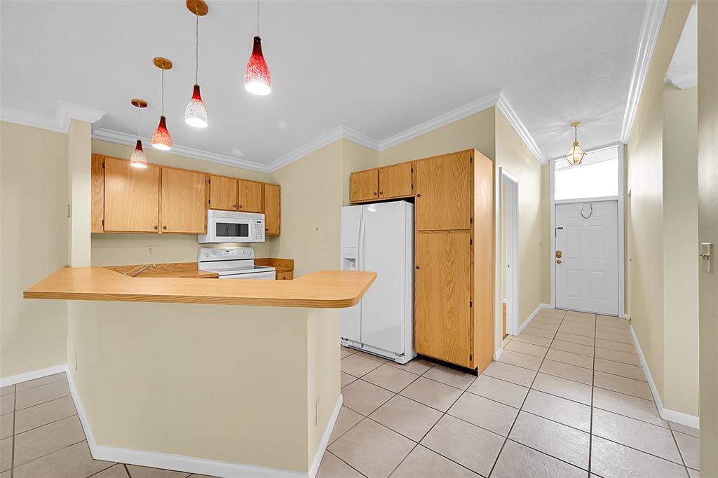 22306 Timberly Drive, Unit 22306 Boca Raton, FL 33428 - Photo 2 of 26 a kitchen with stainless steel appliances granite countertop a refrigerator a sink dishwasher and white cabinets with wooden floor