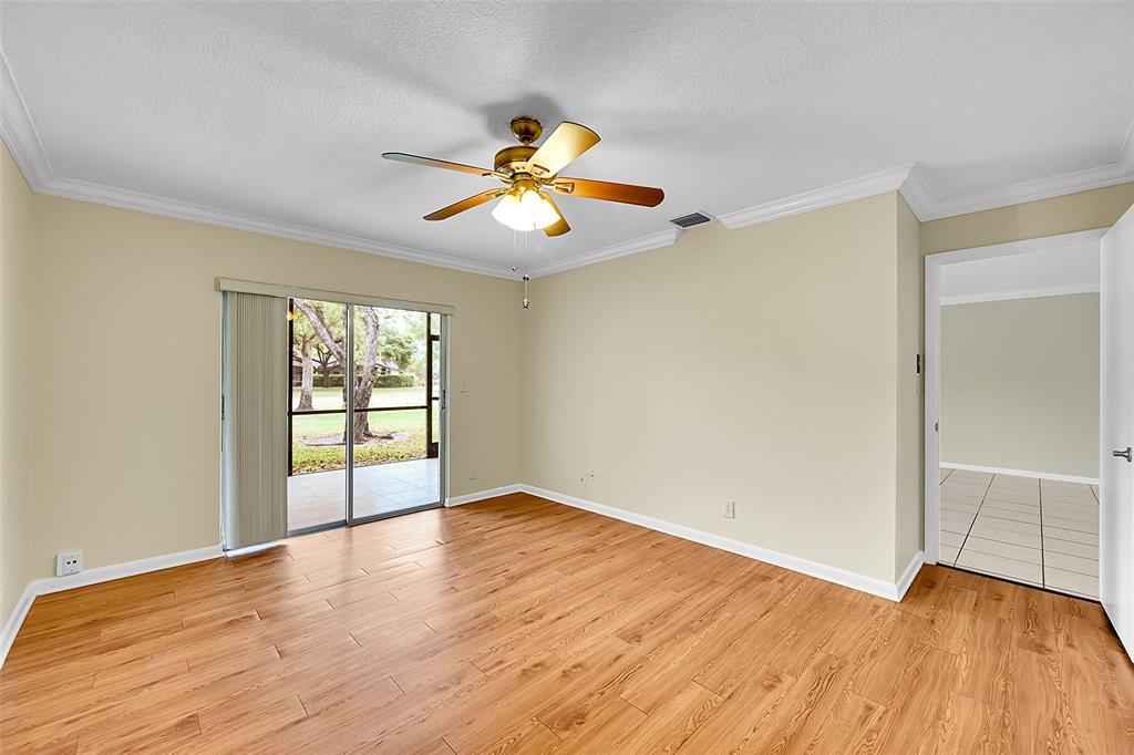 22306 Timberly Drive, Unit 22306 Boca Raton, FL 33428 - Photo 10 of 26 an empty room with wooden floor and windows