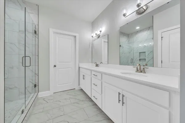 a spacious bathroom with double sink and a mirror