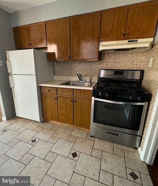 203 Robbins Street Philadelphia, PA 19111 - Photo 11 of 31 a kitchen with a stove a refrigerator and a sink