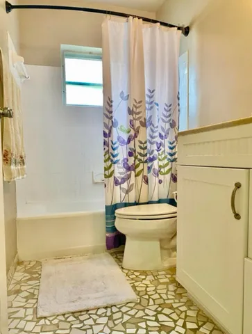 a bathroom with a toilet and a shower