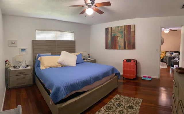 a bedroom with bed and wooden floor