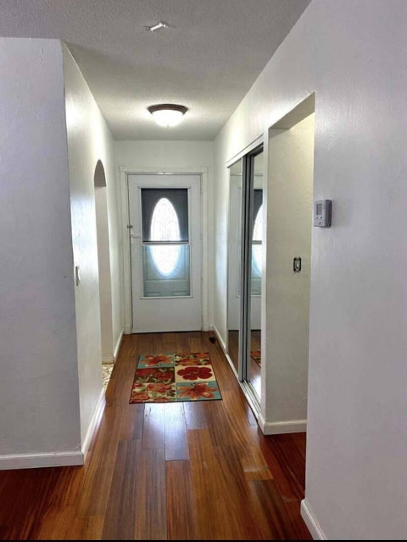 1100 Tallwood Avenue, Unit 201 Hollywood, FL 33021 - Photo 4 of 18 a view of an empty room with wooden floor and a mirror