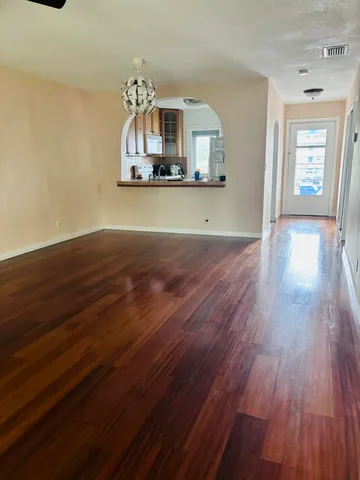 a view of a livingroom with wooden floor and furniture