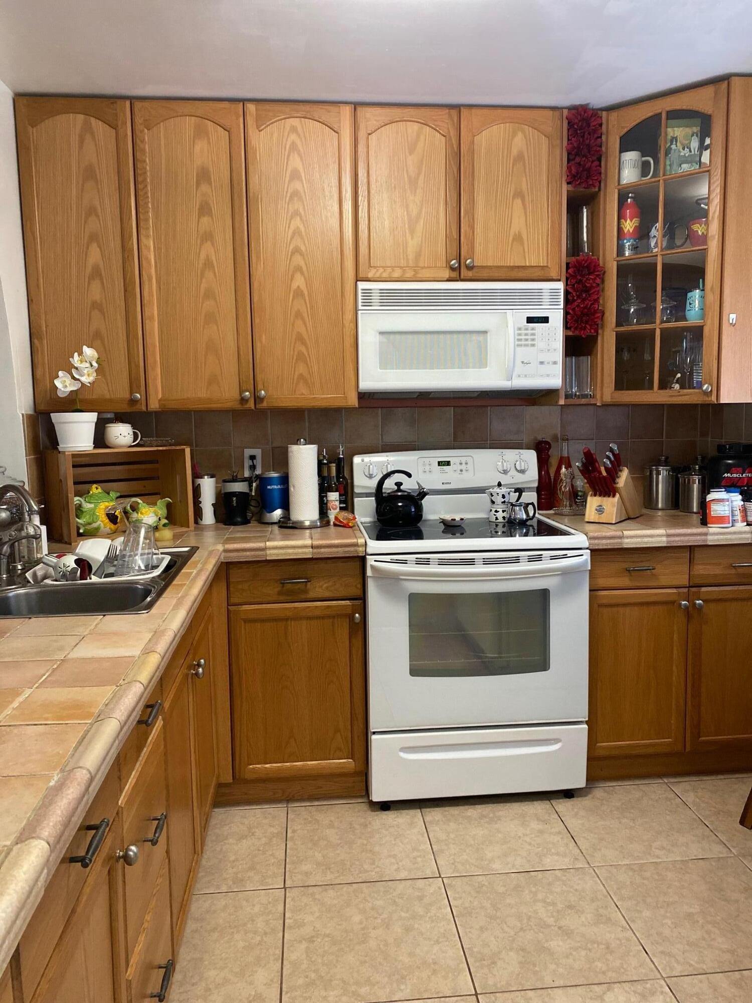1100 Tallwood Avenue, Unit 201 Hollywood, FL 33021 - Photo 10 of 18 a kitchen with a stove a sink and a cabinets