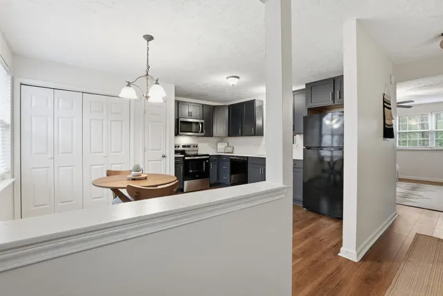 a view of a kitchen center island wooden floor and stainless steel appliances