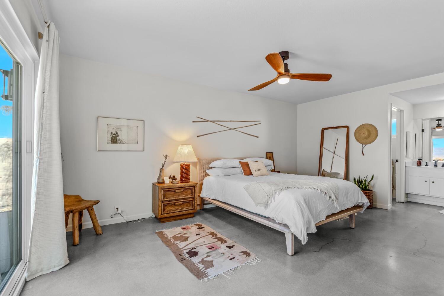 73149 Haystack Road Palm Desert, CA 92260 - Photo 13 of 32 a bedroom with a bed and a chandelier