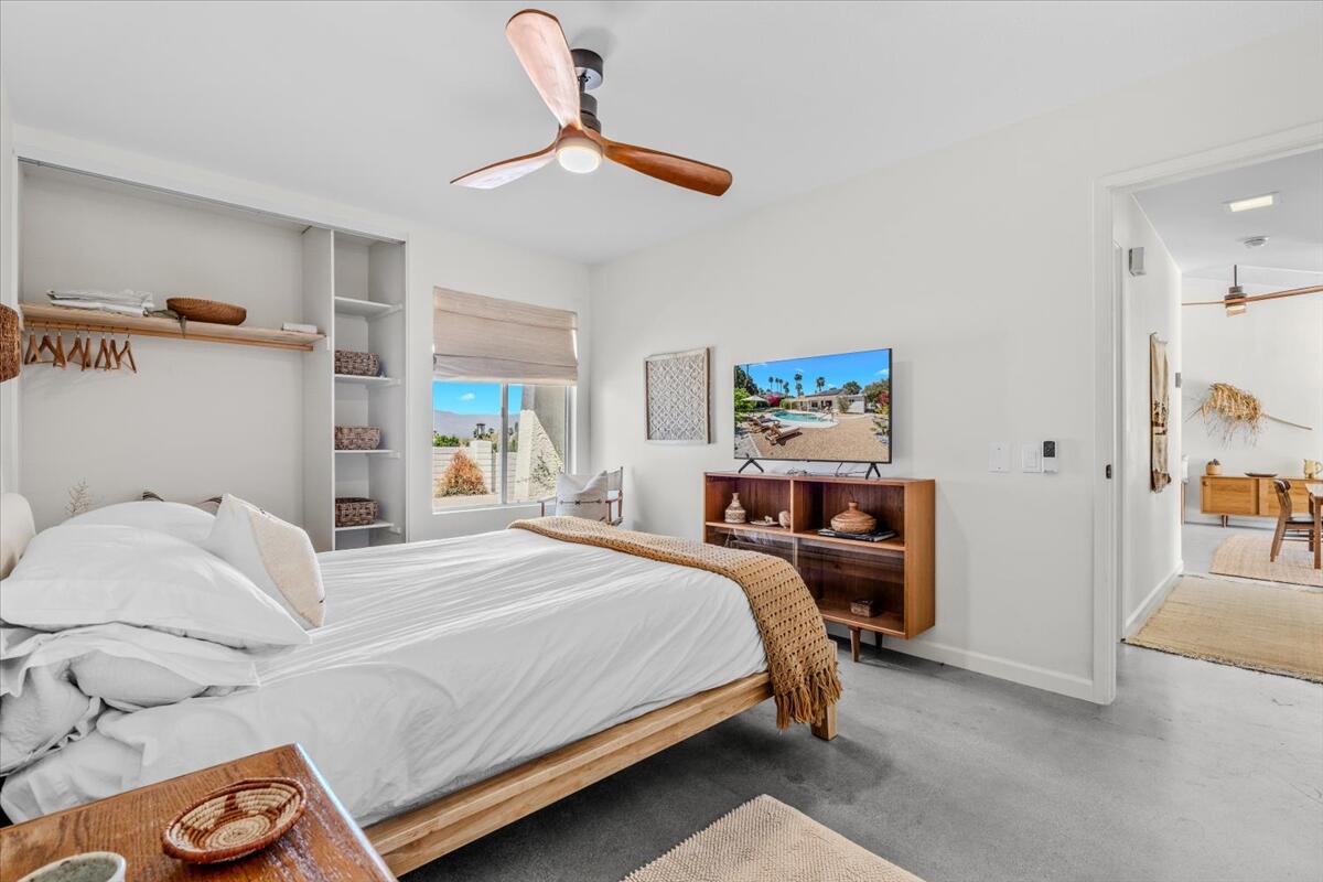 73149 Haystack Road Palm Desert, CA 92260 - Photo 25 of 32 a bedroom with a bed and a chandelier