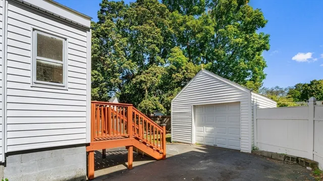 a view of a house with a yard and a large tree