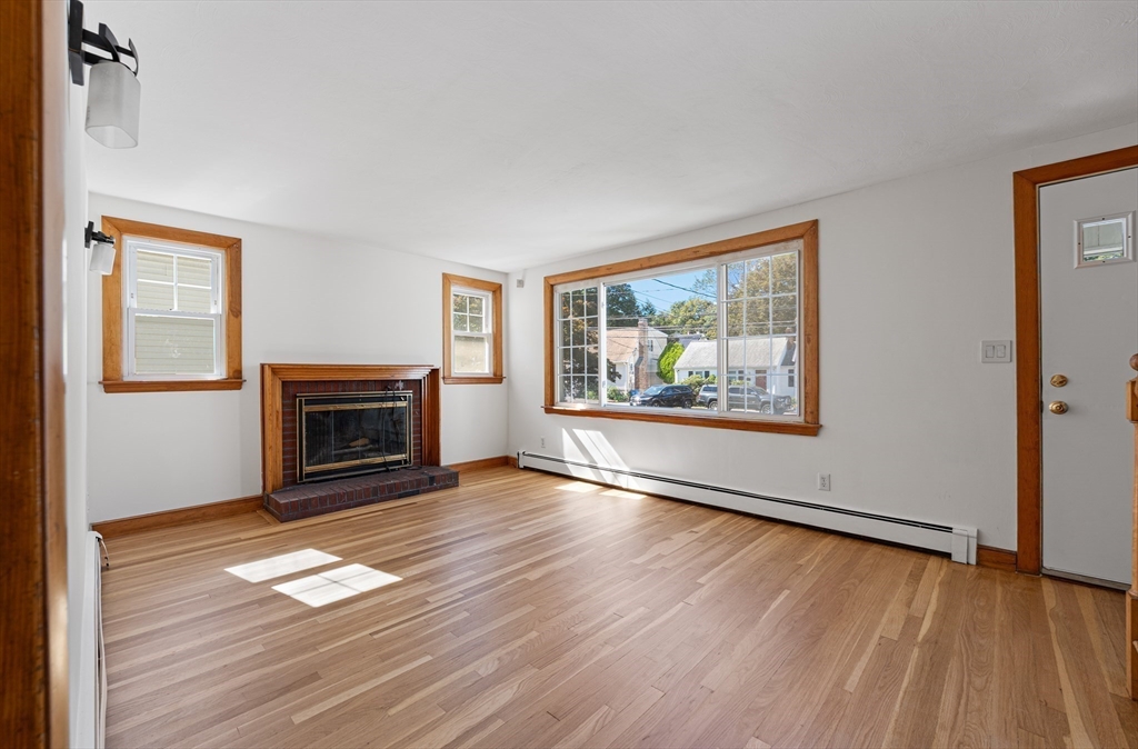 463 Lincoln Street Waltham, MA 02451 - Photo 3 of 23 a view of empty room with wooden floor and fireplace