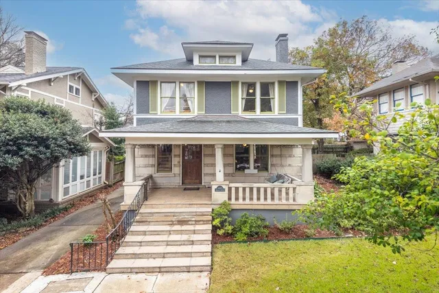 a front view of a house with a garden and balcony