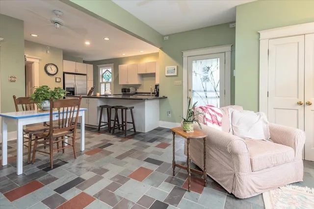 a living room with furniture a rug and kitchen view