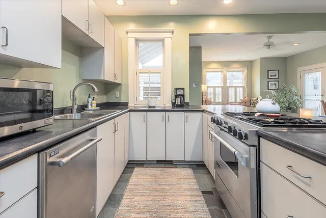 a kitchen with granite countertop a sink stove and cabinets