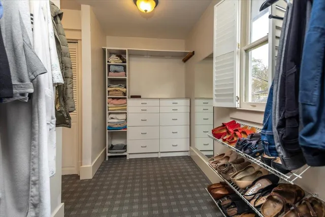 a view of walk in closet with clothes and shoes