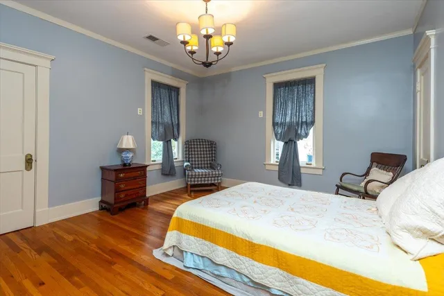 a bedroom with a bed and a chandelier