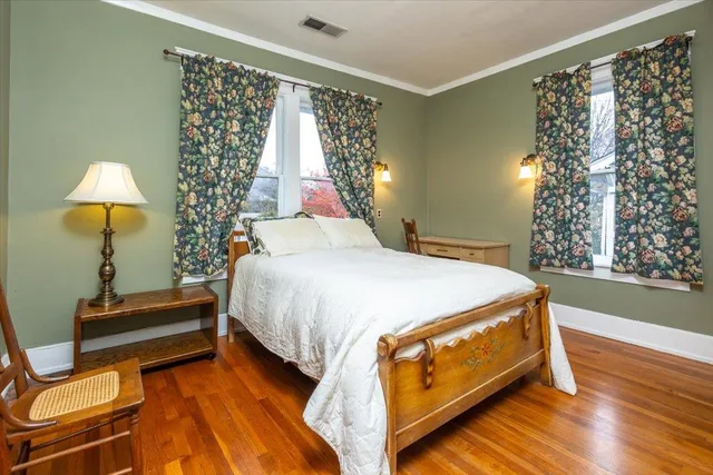 a bed sitting in a bedroom next to a window