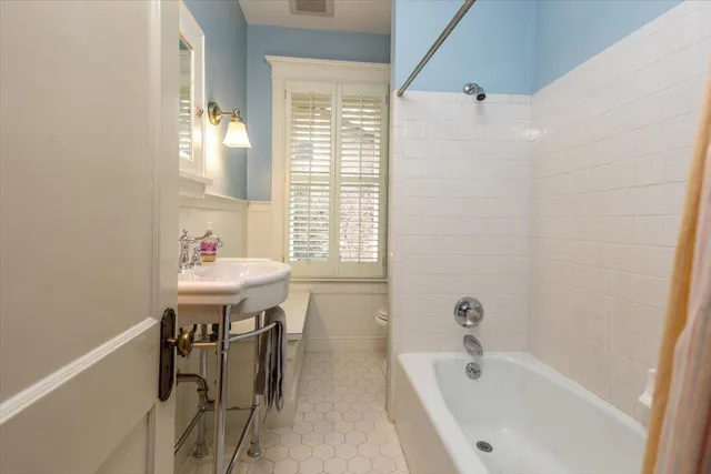 a bathroom with a tub sink and mirror