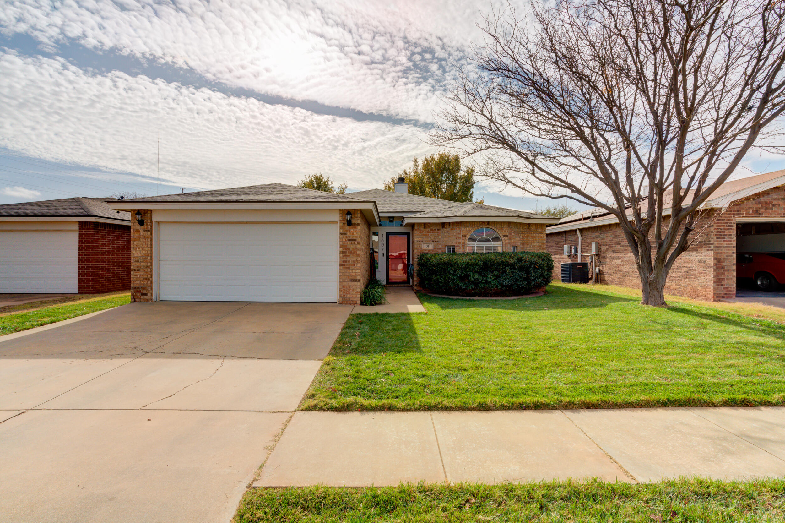 1607 79th Street Lubbock, TX 79423 - Photo 1 of 53 a front view of a house with a yard and garage