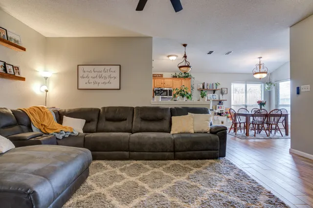 a living room with furniture and a wooden floor
