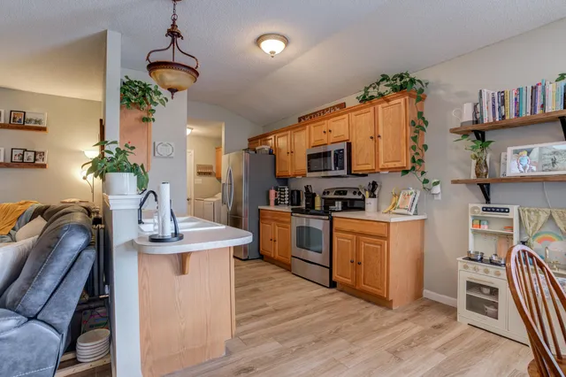 a kitchen with granite countertop a sink appliances cabinets and furniture