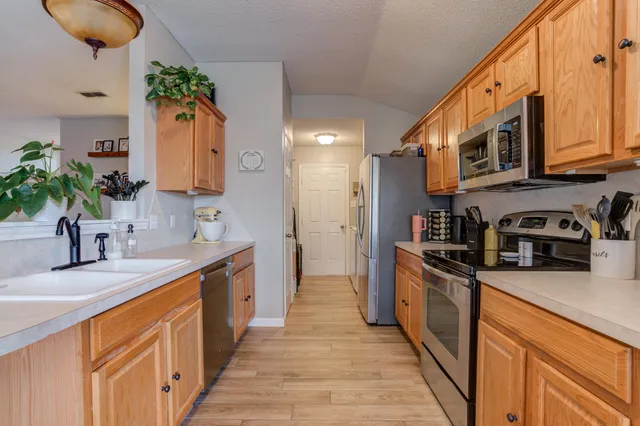a kitchen with stainless steel appliances granite countertop a sink a stove cabinets and a kitchen island