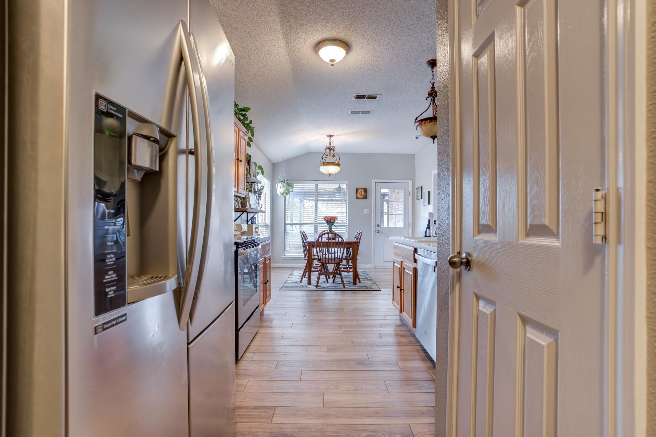 1607 79th Street Lubbock, TX 79423 - Photo 27 of 53 a view of a hallway with dining area wooden floor and a chandelier