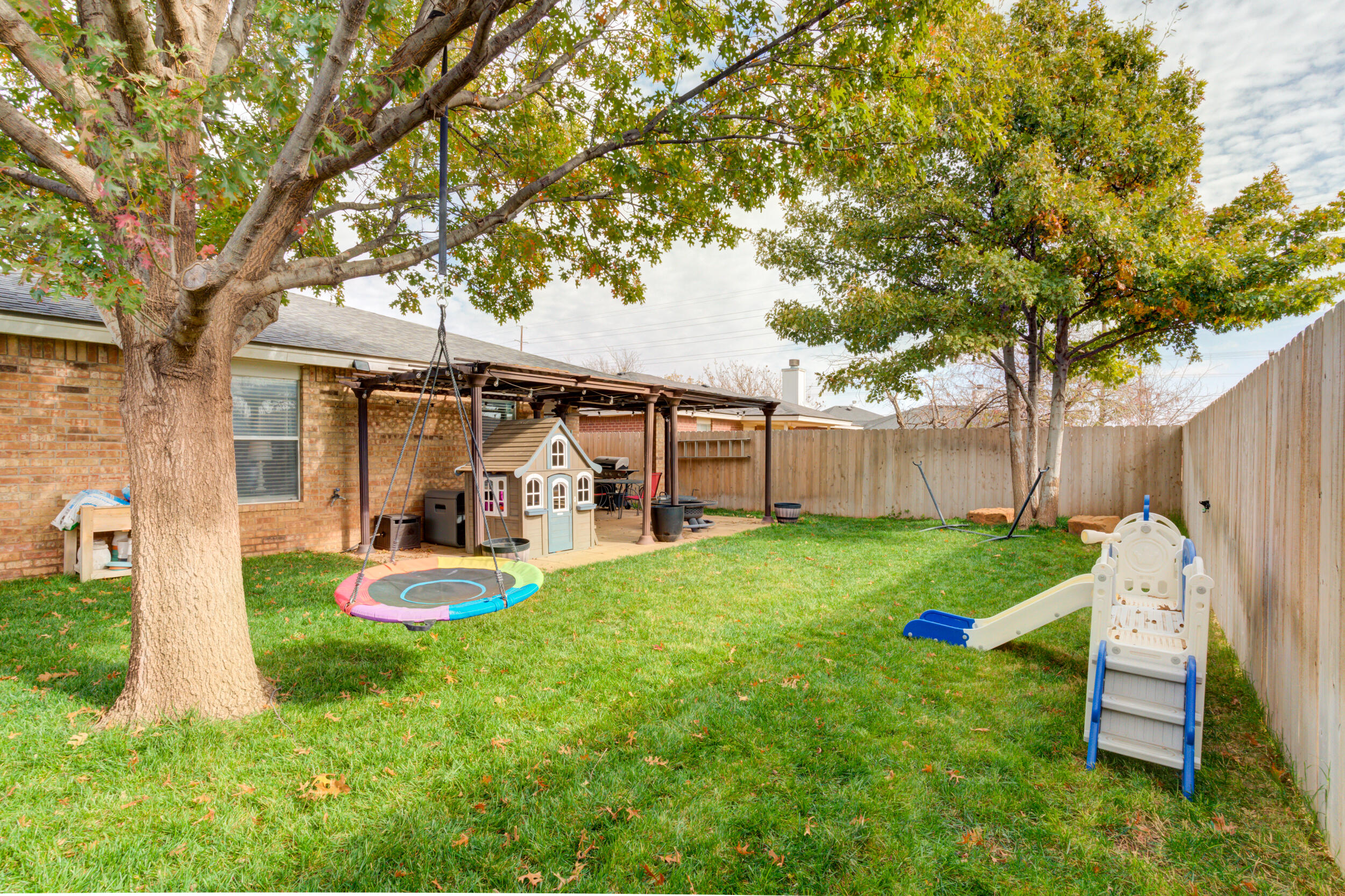 1607 79th Street Lubbock, TX 79423 - Photo 48 of 53 a view of a chair and table in backyard of the house