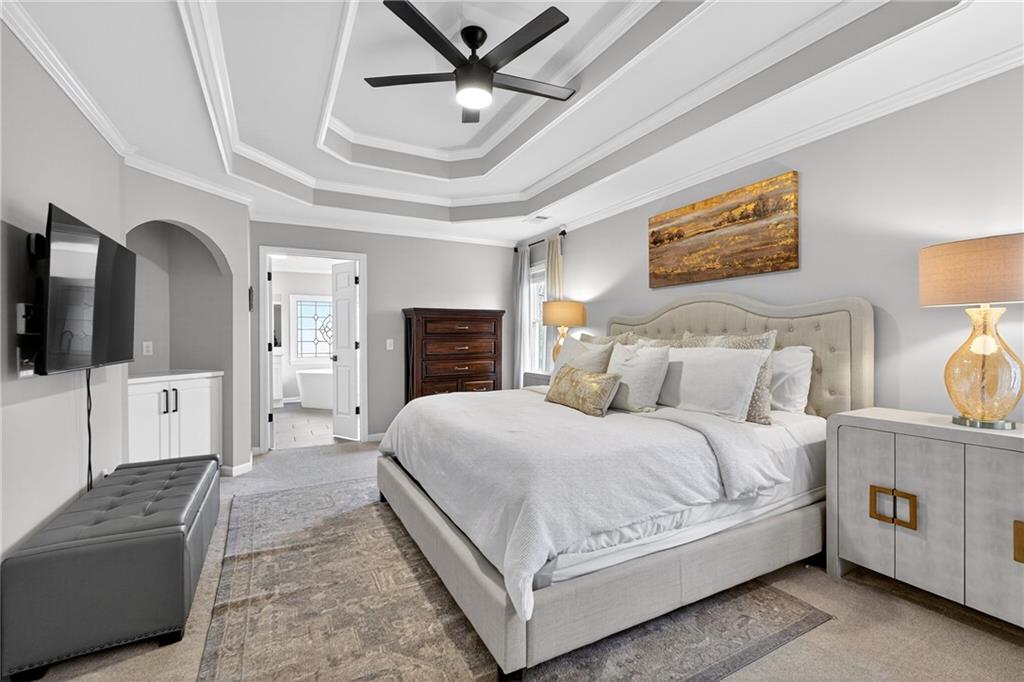 14325 Morning Mountain Way Milton, GA 30004 - Photo 26 of 66 a spacious bedroom with a large bed a flat screen tv and a couch