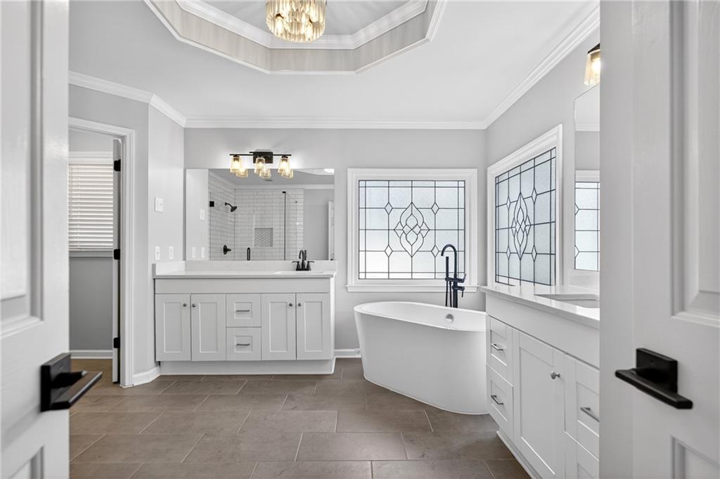 14325 Morning Mountain Way Milton, GA 30004 - Photo 29 of 66 a large bathroom with a double vanity sink a mirror a bathtub and window