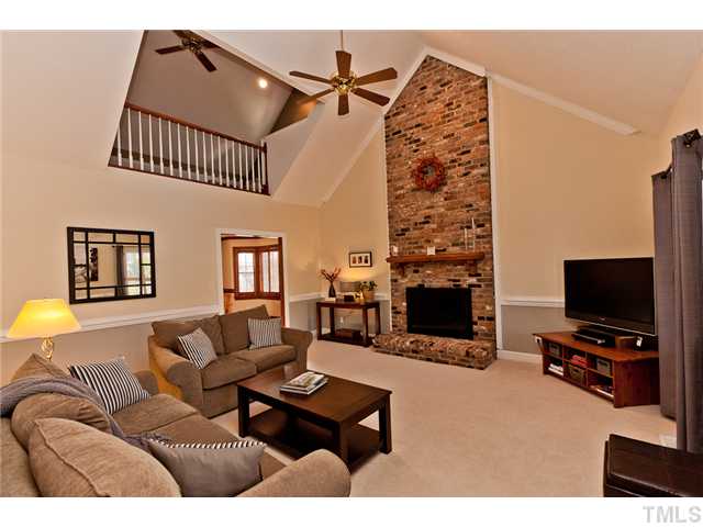 4405 Ennismore Circle Raleigh, NC 27613 - Photo 2 of 21 Family room with cathedral ceiling, floor to ceiling brick fireplace with hearth and gas logs, plantation shutters.