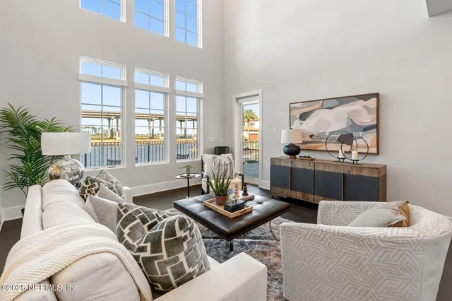 a living room with furniture and a large mirror with wooden floor