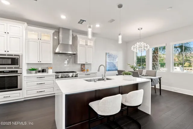a kitchen with granite countertop a sink stove top oven and cabinets