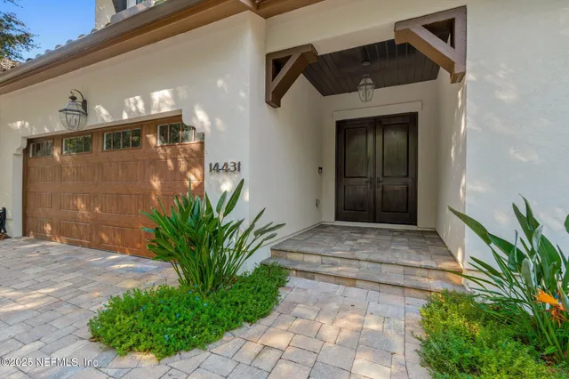 a view of a patio with lawn chairs floor to ceiling window and wooden fence