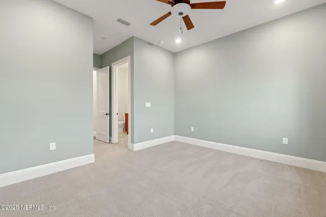 an empty room with a ceiling fan and window
