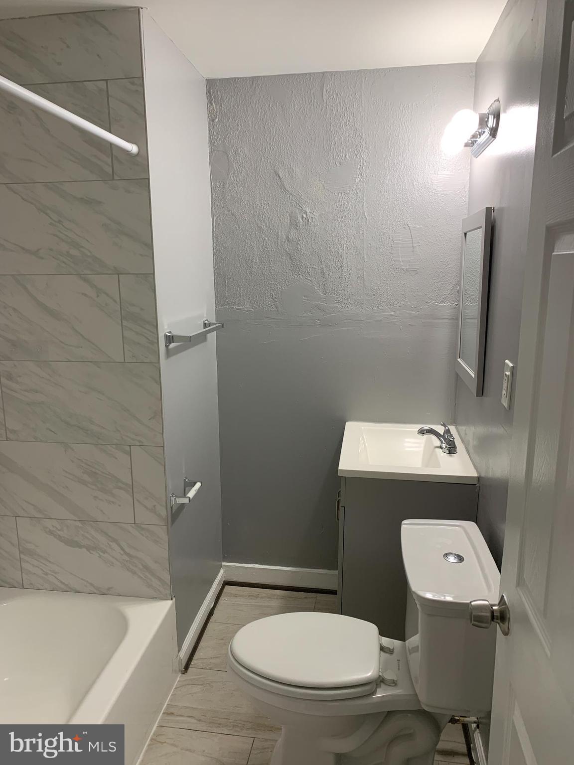 2708 Mathews Street Baltimore, MD 21218 - Photo 13 of 20 a white toilet sitting next to a bath tub and a sink