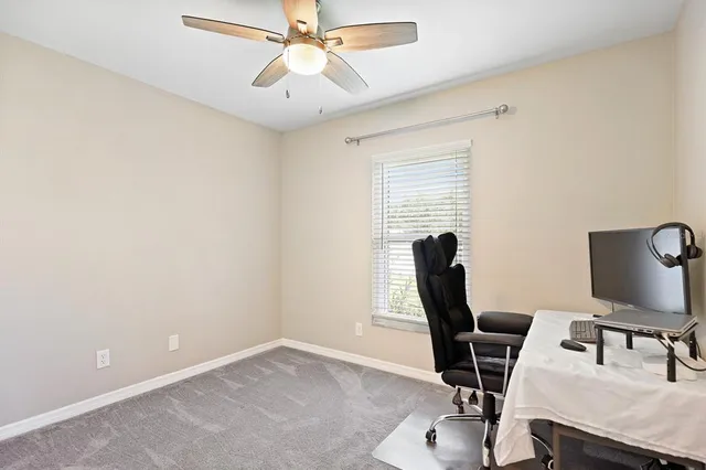 a view of a workspace with furniture and a window