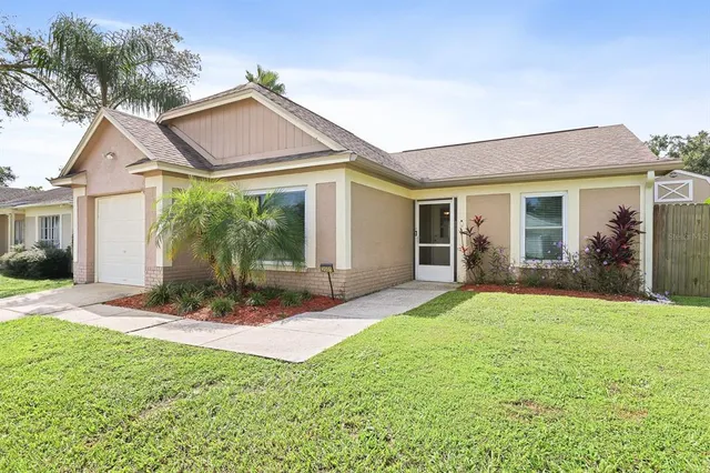 a view of a house with a yard and potted plants