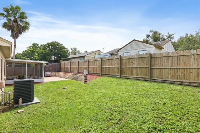 a view of a backyard with a garden and entertaining space