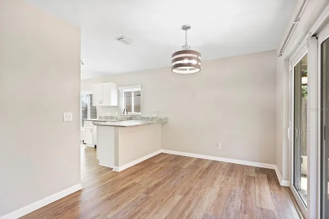 a view of livingroom with kitchen island stainless steel appliances wooden floor and window