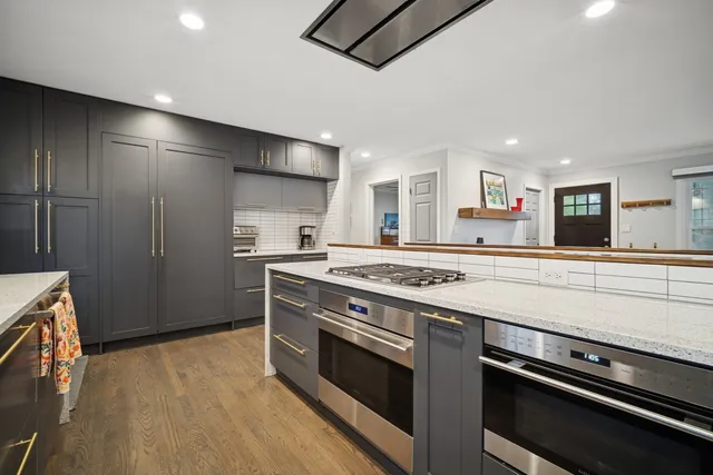 a kitchen with stainless steel appliances granite countertop a stove and a refrigerator
