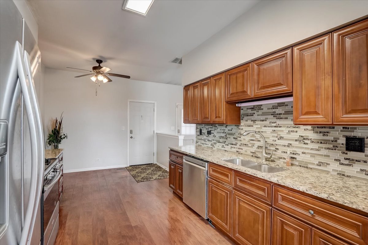 17885 Braewick Road, Unit 17217 Gurnee, IL 60031 - Photo 12 of 35 a kitchen with stainless steel appliances granite countertop a sink a stove cabinets and wooden floor