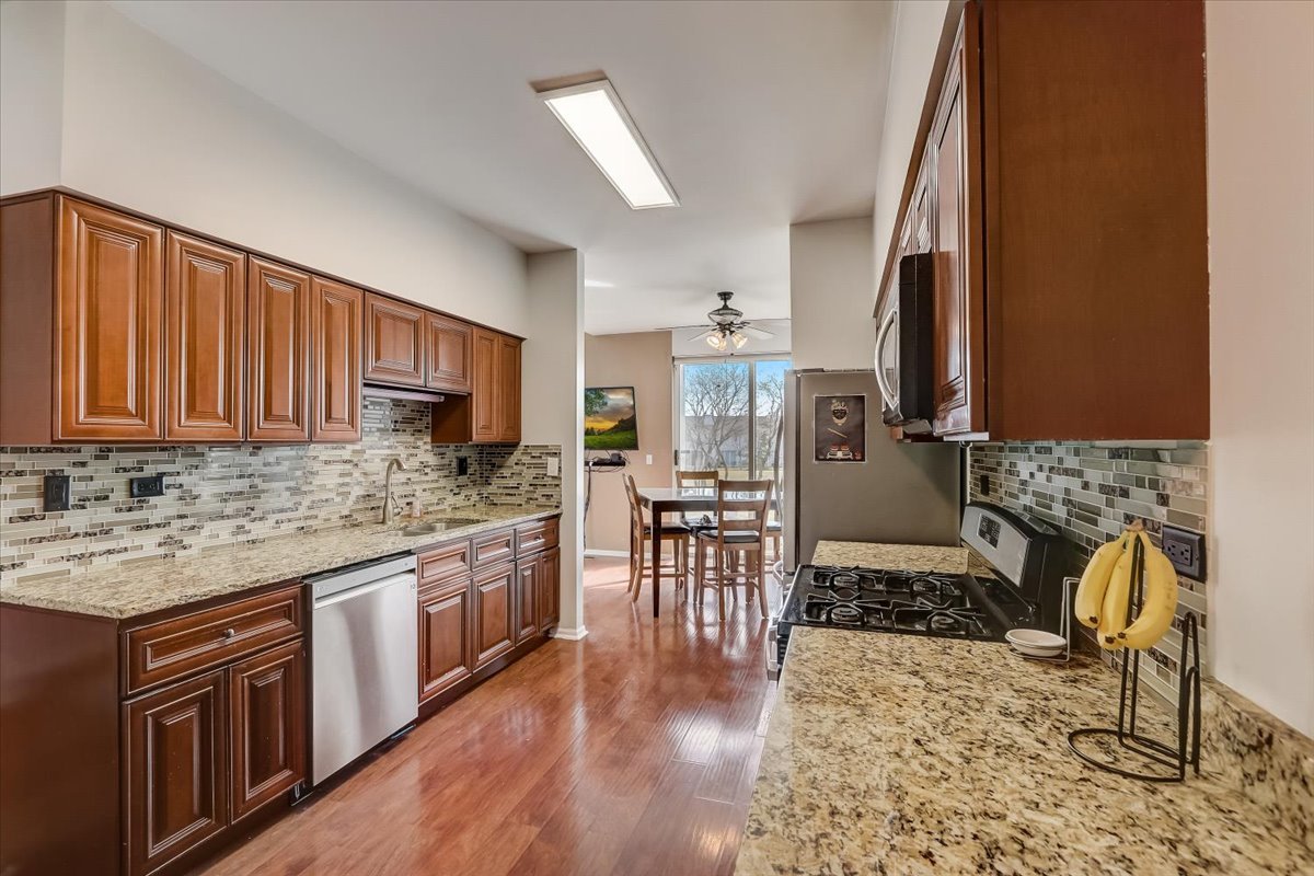 17885 Braewick Road, Unit 17217 Gurnee, IL 60031 - Photo 13 of 35 a kitchen with stainless steel appliances granite countertop sink stove top oven and cabinets