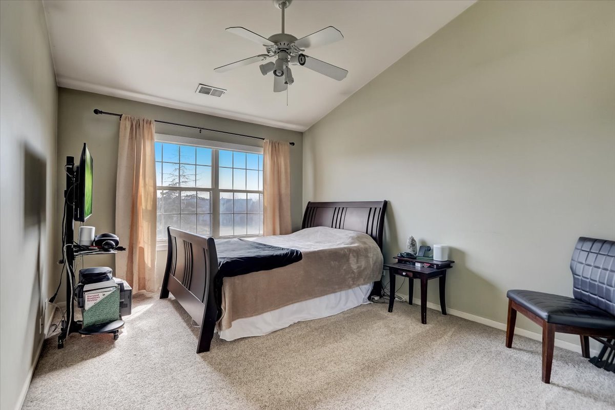 17885 Braewick Road, Unit 17217 Gurnee, IL 60031 - Photo 20 of 35 a bedroom with a bed and a chandelier